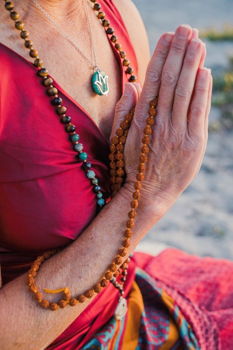 hands in prayer with mala